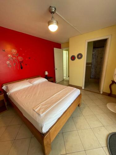 a bedroom with a large bed with a red wall at Apartamento en Atacames con vista al mar in Atacames