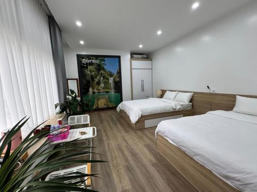 a bedroom with two beds and a large window at Mộc Sơn Homestay in Mộc Châu