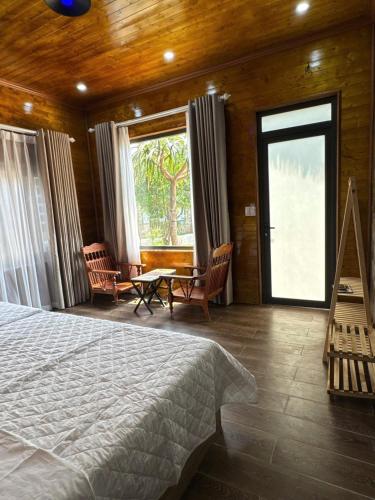 a bedroom with a bed and a table and chairs at Mộc Sơn Homestay in Mộc Châu
