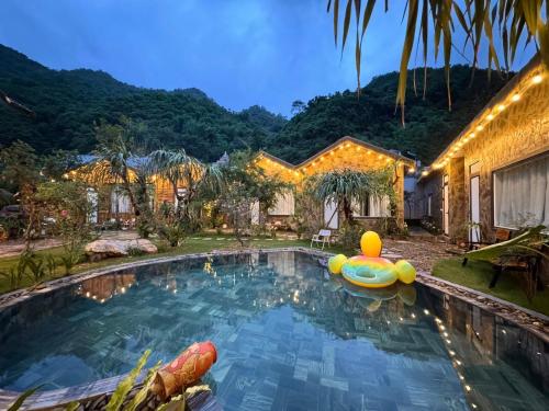 a swimming pool with a pool noodle in front of a house at Mộc Sơn Homestay in Mộc Châu