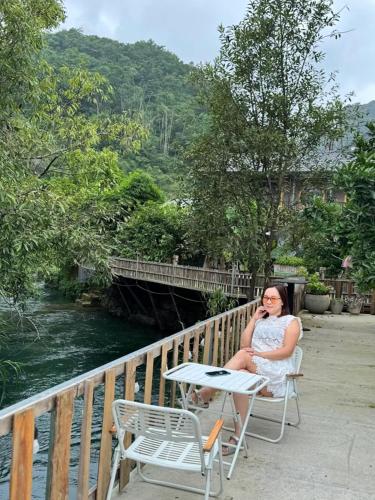 a woman sitting on a chair talking on a cell phone at Mộc Sơn Homestay in Mộc Châu