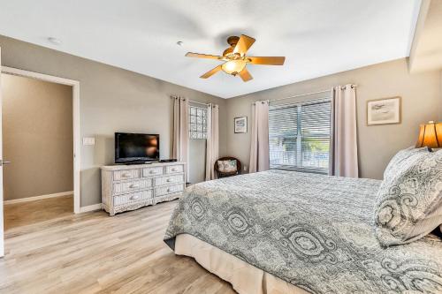 Un dormitorio con una cama y un ventilador de techo. en Oceanside 203, en Clearwater Beach