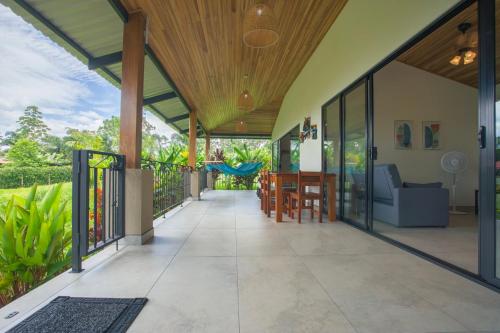 an open patio with a wooden ceiling and glass doors at La Finca Lodge in Fortuna