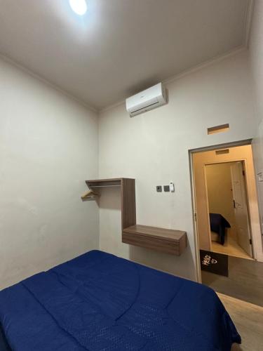 a bedroom with a blue bed and a mirror at ADS House in Padalarang