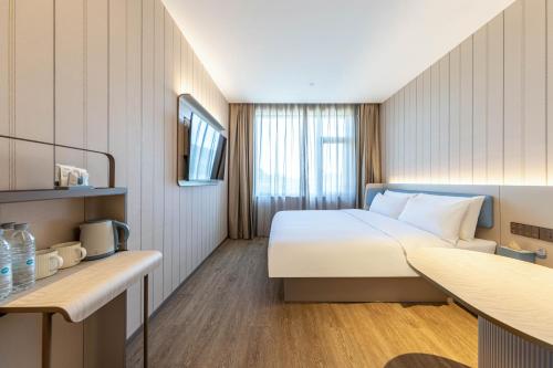 a hotel room with a bed and a desk at Hanting Hotel Beijing Rocket Wanyuan Subway Station in Beijing