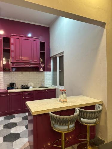 a kitchen with purple cabinets and two bar stools at ADS House in Padalarang