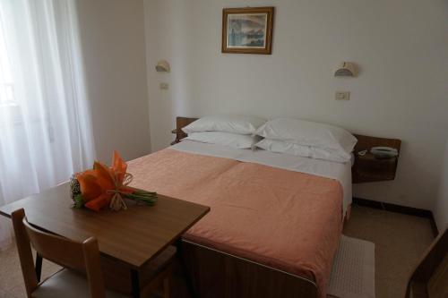 um pequeno quarto com uma cama e uma mesa em Hotel Aurora em Gabicce Mare