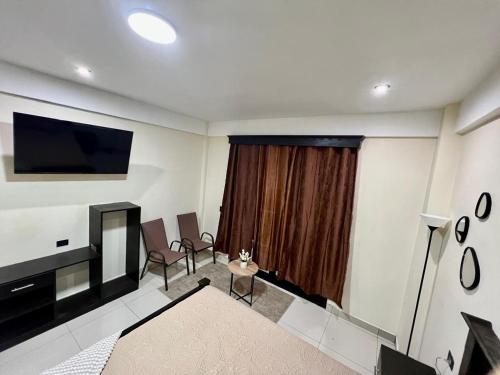 a living room with a fireplace and a television at Hotel San Isidro in Malacatán