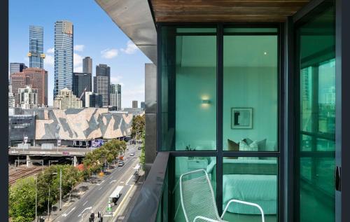a balcony with green chairs and a view of a city at 108 Flinders - Stunning Views & Prime Location in Melbourne