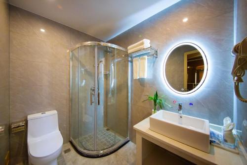 a bathroom with a shower and a toilet and a sink at Airport Boutique Hotel-Free pick-up in Zhangjiajie