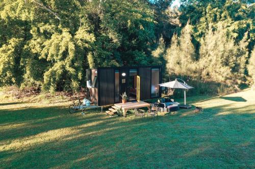 a small cabin in the middle of a grass field at Dreamseed Cabin by Tiny Away in Yandina