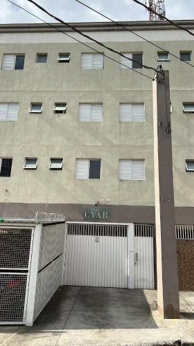 a building with a garage door in front of it at Studio Cyar 44 - Ar-condicionado e Conforto in Taubaté