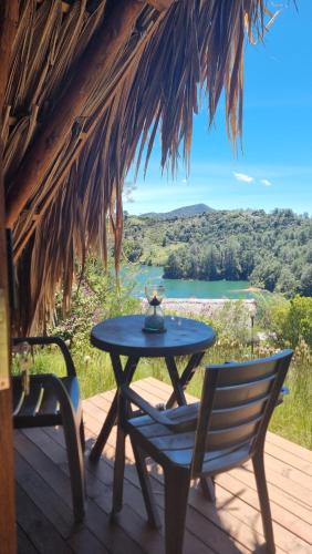 a table and chairs on a deck with a view at Hotel Pietrasanta in Guatapé