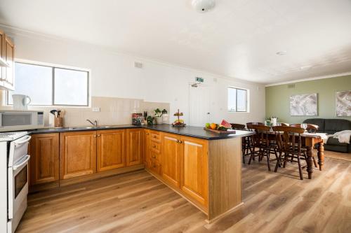 a kitchen with wooden cabinets and a dining room at Barossa Palms Motel in Nuriootpa