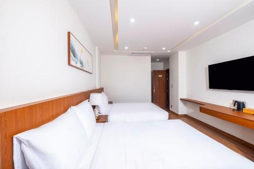 a hotel room with a bed and a flat screen tv at Great Hotel Phú Quốc in Phu Quoc