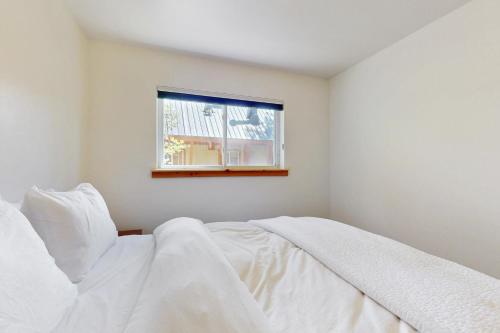 a bedroom with a white bed and a window at West End Escape in Truckee