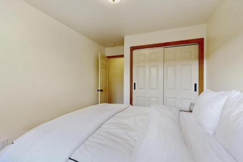a white bed in a room with a door at West End Escape in Truckee
