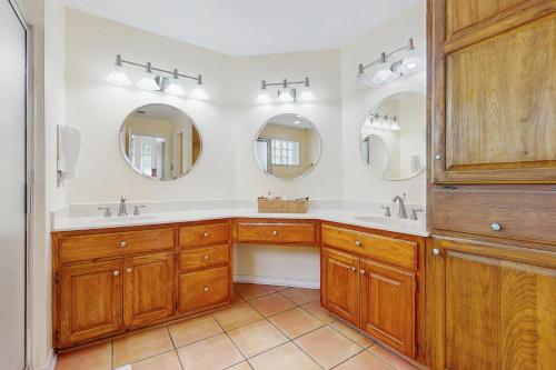 a bathroom with two sinks and two mirrors at Pelican Pete in Corpus Christi