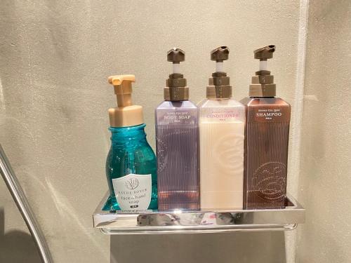 a shelf with four bottles of soap and shampoo at ザマミセカンドスタイル in Zamami
