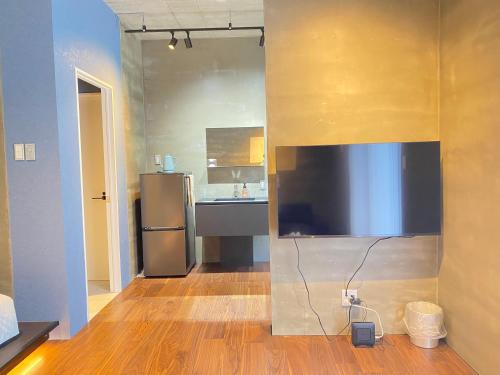 a kitchen with a large flat screen tv on a wall at ザマミセカンドスタイル in Zamami