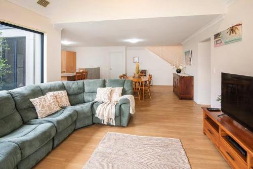 a living room with a couch and a television at Thomas Place- WIFI, Kayaks, Bikes, Secure Yard in Busselton