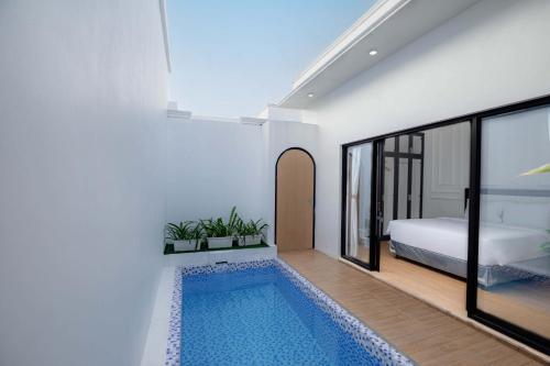 a bedroom with a swimming pool next to a bed at Marina Villa 1 in Yogyakarta