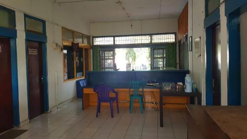a kitchen with two chairs and a table in a room at Guest House Dorm Floressa in Maumere