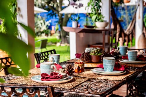 a table with plates and cups on top of it at Pancha Mama Hotel Boutique in Villa de Leyva