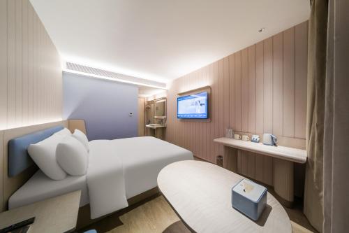 a hotel room with a bed and a tv at Hanting Hotel Beijing Fangshan Changyang Aerospace City Electronic Technology Park in Beijing