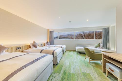 a hotel room with two beds and a window at KAMENOI HOTEL Nagatoro Yorii in Yorii