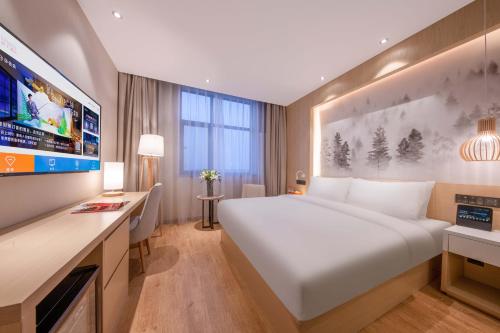 Ένα ή περισσότερα κρεβάτια σε δωμάτιο στο Orange Hotel Beijing Jiugong