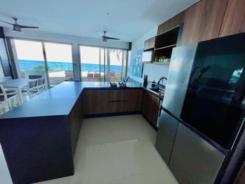 a kitchen with a refrigerator and a counter top at Angelina 28 Beachfront and Family Apartments - Modern and Relaxing Long Stays - 20 min from Cancun Airport in Puerto Morelos