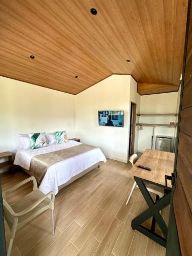 a bedroom with a bed and a wooden ceiling at La Capilla EcoHotel in Moniquirá
