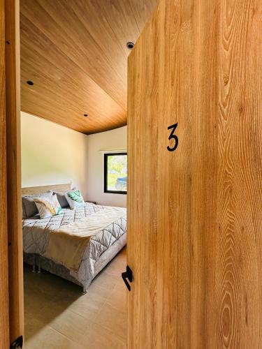 a bedroom with a bed and a wooden wall at La Capilla EcoHotel in Moniquirá