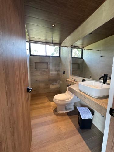 a bathroom with a toilet and a sink at La Capilla EcoHotel in Moniquirá