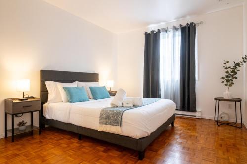 a bedroom with a large bed with blue pillows at Maison Spacieuse 3CH Piscine et Jardin Privé in Longueuil
