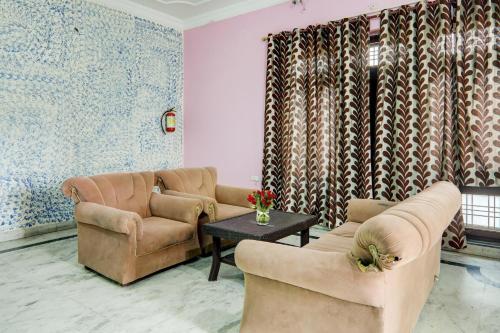 a living room with two couches and a table at Super Hotel O Kiara Villa Matiyari Chauraha Chinhat Bus Stop in Chinhat