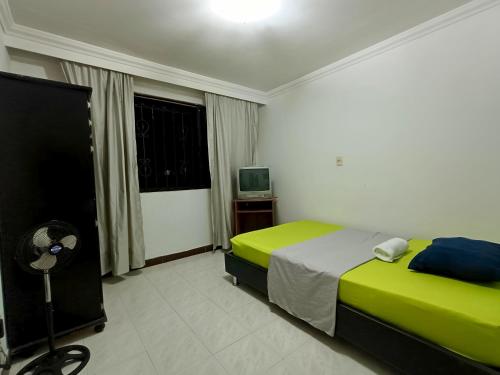 a bedroom with a bed and a television in it at Casa Belmonte Pereira, Amplia, con Garaje y cerca a ExpoFuturo in Estación El Salto
