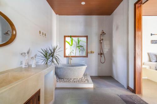 a bathroom with a tub and a sink at Luxury 3BR Noa Villa Private Pool in Gili Air