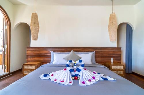 a bedroom with a bed with a bow on it at Luxury 3BR Noa Villa Private Pool in Gili Air