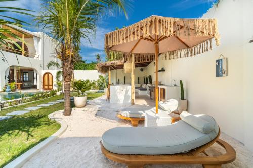 a patio with a couch and an umbrella at Luxury 3BR Noa Villa Private Pool in Gili Air