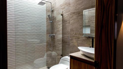 a bathroom with a shower with a toilet and a sink at Las Olas del Surf in Ayampe
