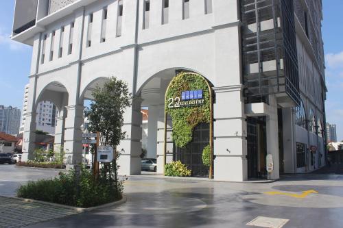 a large white building with an archway on a street at 22 Macalisterz by ALV in George Town