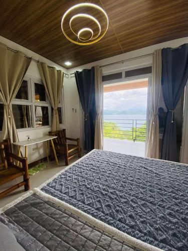 a bedroom with a large bed with a large window at CJ's Place Mabini in Mabini