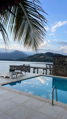 a swimming pool with a view of a body of water at EXCLUSIVIDADE à beira-mar in Angra dos Reis