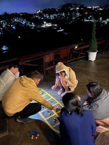 a group of people playing a game with a child at Nhà Tĩnh - Tiệm Cà phê Tĩnh 2 in Ấp Ða Lợi