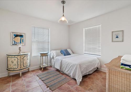 a bedroom with a bed and a table and windows at Seaside Serenity 3-Bedroom Shore home 2 blocks to the beach and boardwalk in Seaside Heights
