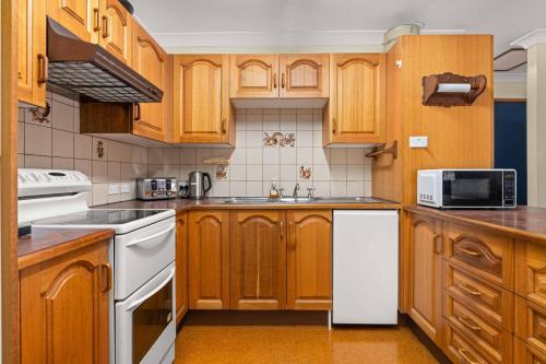 a kitchen with wooden cabinets and white appliances at OP Chill in Orient Point