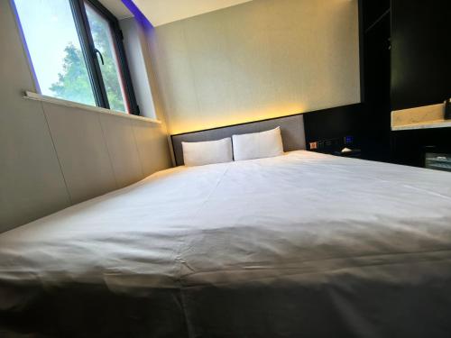 a large white bed in a room with a window at Ibis Beijing Shichahai Gulou Street Subway Station Hotel in Beijing