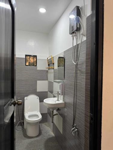 a bathroom with a toilet and a sink at GLC Tourist Inn in Coron